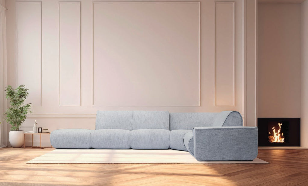Canapé d'angle Move aux modules arrondis en tissu bleu-gris, dans un salon avec cheminée