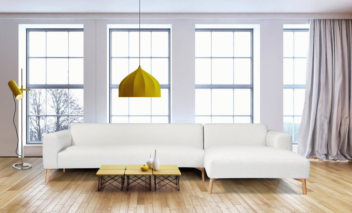 Canapé d'angle Light en tissu blanc cassé sur pieds en bois naturel, dans un salon aux grandes fenêtres