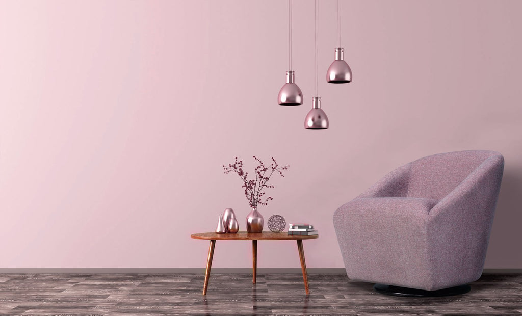 Fauteuil cocon Flamingo en tissu vieux rose sur pied central en métal, à côté d'une table basse en bois