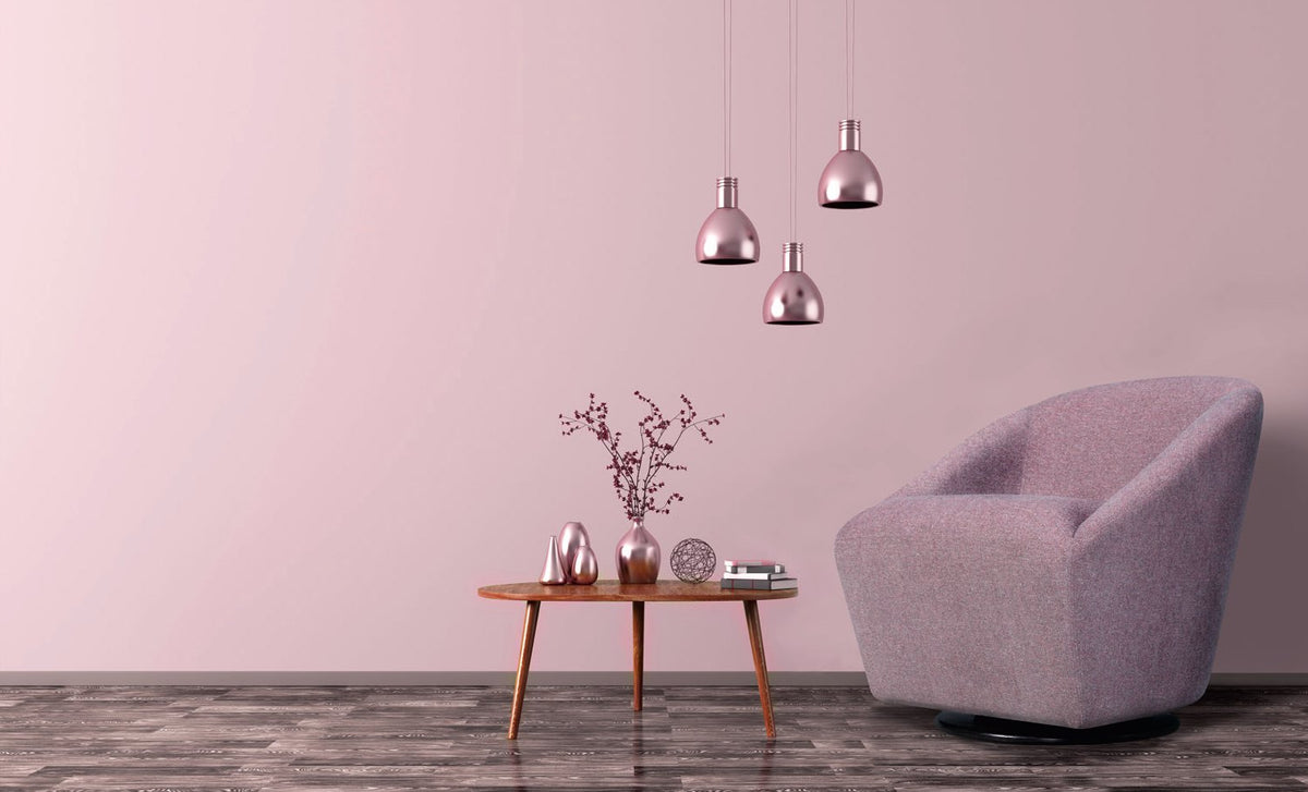 Fauteuil cocon Flamingo en tissu vieux rose sur pied central en métal, à côté d'une table basse en bois