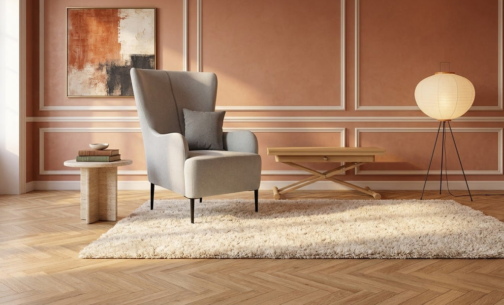 Fauteuil Harry en tissu gris clair dans un salon aux murs terracotta et moulures blanches – mise en situation