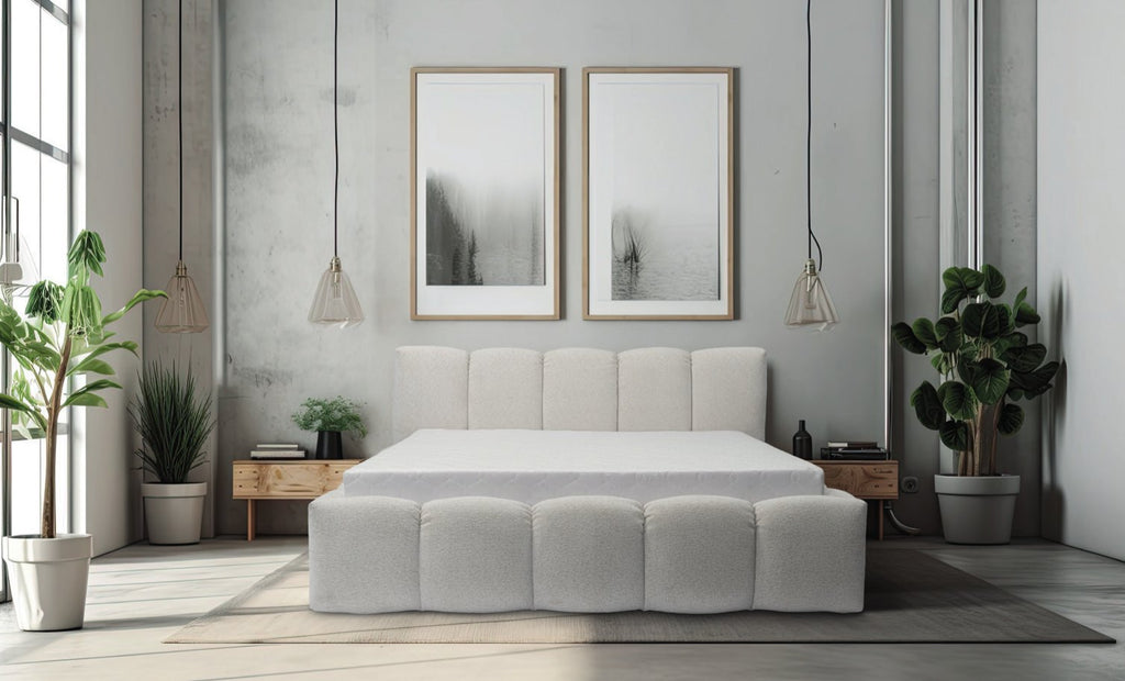 Lit Bubble en tissu bouclé écru, tête et pied de lit capitonnés en boudins arrondis, dans une chambre lumineuse